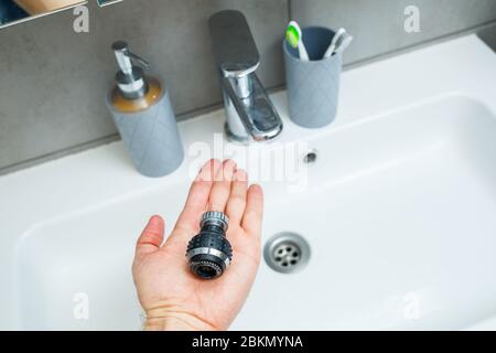 Drehdüse am Mischer zur Einstellung des Wasserflusses. Weißes Waschbecken im Badezimmer zum Händewaschen Stockfoto