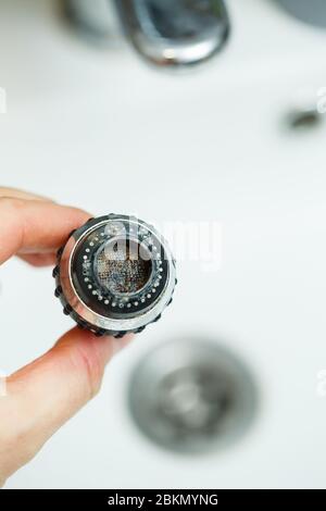 Drehdüse am Mischer zur Einstellung des Wasserflusses. Weißes Waschbecken im Badezimmer zum Händewaschen Stockfoto