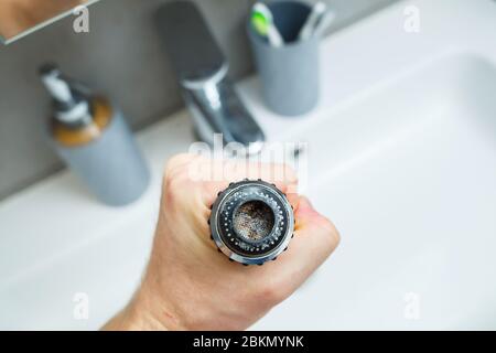 Drehdüse am Mischer zur Einstellung des Wasserflusses. Weißes Waschbecken im Badezimmer zum Händewaschen Stockfoto