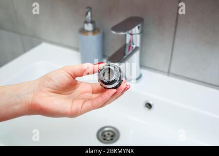 Drehdüse am Mischer zur Einstellung des Wasserflusses. Weißes Waschbecken im Badezimmer zum Händewaschen Stockfoto