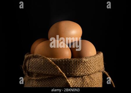 Nahaufnahme Ei in Baumwollsack auf schwarzem Hintergrund. Stockfoto
