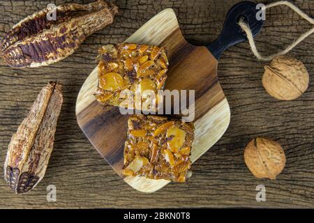 Flach legen Toffee Kuchen Quadrate auf Holztablett und auf Holztisch Hintergrund. Stockfoto