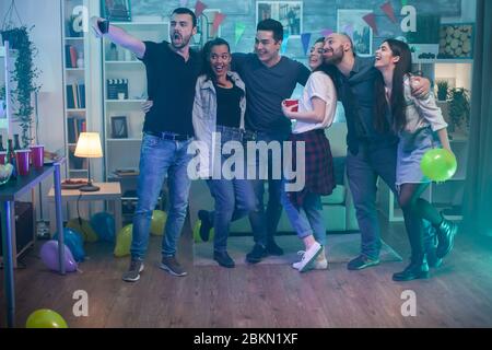 Fröhliche Männer und Frauen machen ein Selfie auf der Party. Freundschaft feiern. Stockfoto