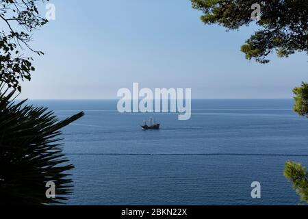 Dubrovnik, Kroatien, 18. September 2019. Der Blick auf die Adria durch typisch mediterrane Vegetation mit dem berühmten Karaka Boot von Game of Stockfoto