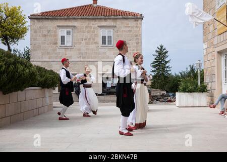 Konavle, Kroatien, 5. Oktober 2019. Eine Gruppe von Männern und Frauen, die traditionelle kroatische Folklore-Kostüme tragen, während sie tanzen und eine Show in einer r Stockfoto