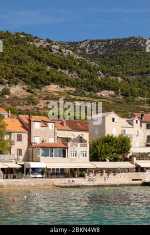 Bol, Kroatien, 10. September 2019. Ein Boulevard und der Hafen von Bol auf der Insel Brac in Dalmatien an einem sonnigen Tag im Sommer. Ein Boot und Touristen zu Fuß Stockfoto