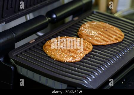 Vollkornburger auf elektrischem Grill Stockfoto