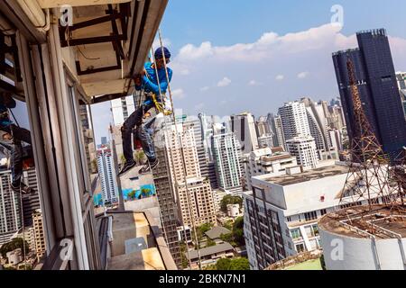 Steeplejack arbeitet an der Außenseite des Wolkenkratzers, Bangkok, Thailand Stockfoto