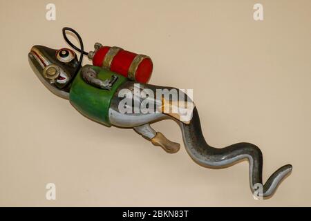 Statue des Geckos mit Tauchausrüstung an der Wand des Tauchzentrums. 3D Gecko als Taucher. Eidechse Figur mit grüner Jacke, rotem Tauchbecken und gelb Stockfoto