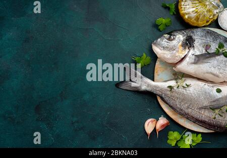 Rohe dorado-Fische und Zutaten auf trendigem türkisfarbenem Hintergrund mit Platz für einen Text Stockfoto