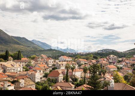 Blick über Cavtat mit seinen weißen Häusern und orangefarbenen Dächern und die schönen Berge und das Grün im Hintergrund an einem bewölkten Tag im Sommer Stockfoto