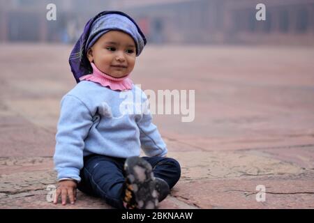 Nettes Baby Mädchen mit Kopftuch lächelnd Stockfoto