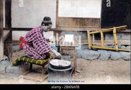 [ 1910er Japan - Japanische Seidenfarm ] - EINE Frau in Yukata und traditioneller Frisur ist Handseide aus Kokons. Diese Postkarte stammt aus einer Serie über die Serikultur, die die Schritte zeigt, die bei der Seidenherstellung erforderlich sind. Dies ist Karte 11. Vintage-Postkarte des 20. Jahrhunderts. Stockfoto