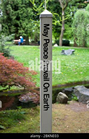 Ein Friedenspol mit den Worten 'Friede siege auf Erden' in einem Park in New Westminster, British Columbia, Kanada Stockfoto