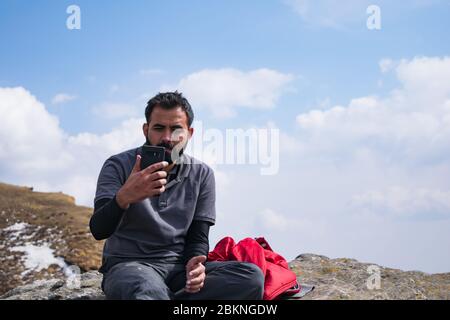 Junger indischer bärtiger Mann, der Selfie inmitten von Chandrashila Trek nimmt Stockfoto