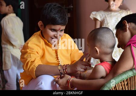 Junger Bruder neckt seine kleine Schwester auf Raksha Bandhan (Rakhi) Stockfoto