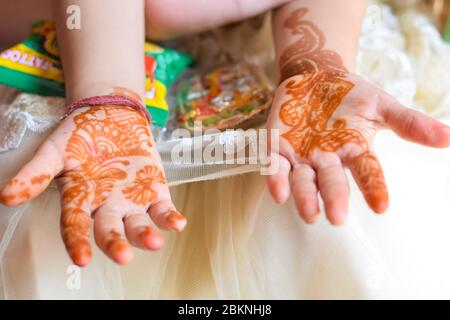 Nettes kleines Mädchen zeigt mehendi Kunst auf ihren Händen Stockfoto