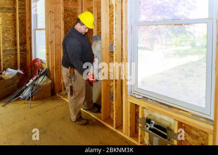 Arbeitsprozess auf der elektrischen Drähte in Wänden Neubau Haus Stockfoto