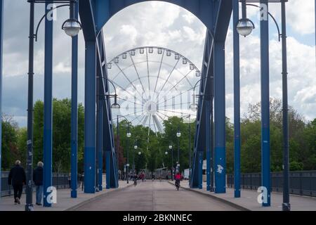 05. Mai 2020, Sachsen-Anhalt, Magdeburg: Zwischen den Bäumen des Rotehornparks steht ein Riesenrad. Derzeit arbeiten die Betreiber ein Konzept aus, um die Abstandsregeln einzuhalten. Das Riesenrad wurde in den vergangenen Wochen gebaut und wird von den Gebrüdern Boos aus Magdeburg betrieben. Eigentlich hätte die Fahrt im Moment auf anderen Messen betrieben werden sollen. Sie waren jedoch wegen der Ausbreitung des Corona-Virus abgesagt worden. Jetzt befindet sich das Riesenrad in der Landeshauptstadt und soll in den kommenden Wochen ohne Messe in Betrieb gehen. Foto: Klaus-Dietmar Gabbert/dpa-Zentralbild/ZB Stockfoto