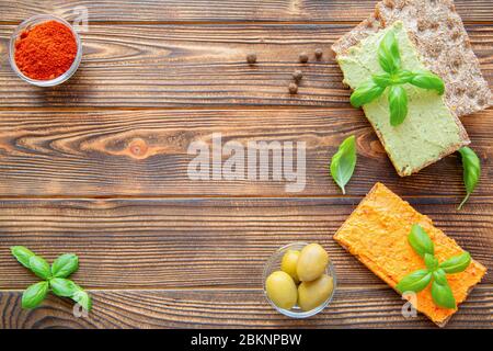 Avocado und Paprika schmackhafter Hummus auf rustikalem Holztisch Hintergrund, Draufsicht. Freier Speicherplatz. Stockfoto