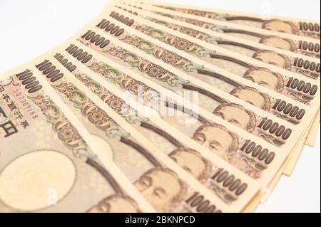 Nahaufnahme von 100,000 Yen in Schichten von 10,000 Yen-Banknoten. Isoliert auf weißem Hintergrund. Horizontale Aufnahme. Stockfoto