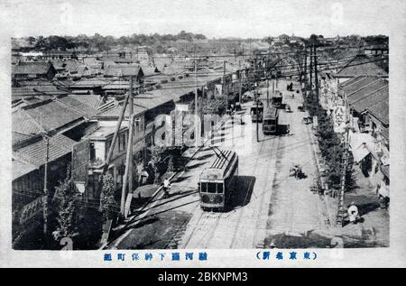 [ 1920er Jahre Japan - Straßenbahnen in Tokio ] - Straßenbahnen auf Jinbocho Dori in Jinbocho (神保町), Tokio. Nachdem das Gebiet 1913 durch einen großen Brand zerstört wurde (Taisho 2), gründete Shigeo Iwanami in diesem Gebiet eine Buchhandlung, die sich zum Iwanami Shaten Verlag entwickelte und das Gebiet als Zentrum für gebrauchte Buchhandlungen und Verlage in Tokio einleitete. Vintage-Postkarte des 20. Jahrhunderts. Stockfoto