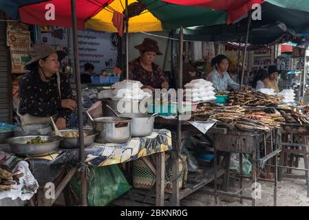 Kambodschanische Frauen verkaufen gekochten Fisch zum Mitnehmen auf dem Fischmarkt, Phnom Penh, Kambodscha Stockfoto