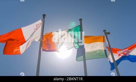 Konzept der Diplomatie und der internationalen Angelegenheiten. Bunte Fahnen von Malta, Irland, Indien, Kroatien flattern im Wind gegen blauen Himmel. Sommertag Stockfoto