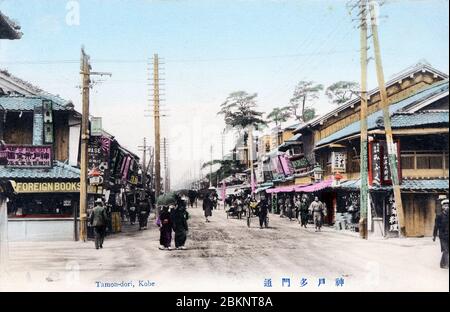 [ 1900er Japan - Japanische Einkaufsstraße, Kobe ] - Tamondori (多聞通) in Kobe, Präfektur Hyogo von Aoioibashi (相生橋) aus gesehen. Die Kiefern auf der rechten Seite finden Minatogawa Jinja. Der Laden links wirbt für ausländische Bücher und eine Karte von Kobe City. Vintage-Postkarte des 20. Jahrhunderts. Stockfoto