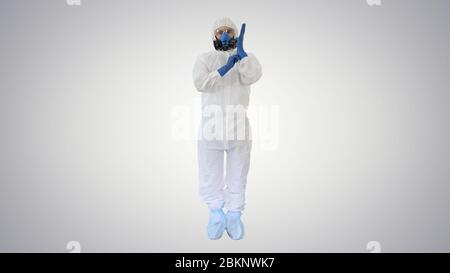 Mann trägt HAZMAT Protective Clothing zeigt, dass er Handschuhe trägt auf Steigung Hintergrund. Stockfoto