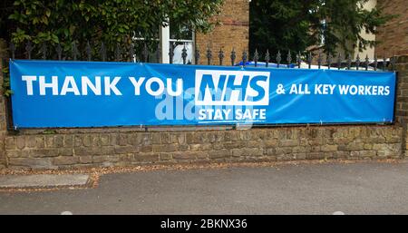 Großes Banner vor einem Wohnhaus, in Dankbarkeit an alle Mitarbeiter des NHS und Schlüsselarbeiter, die während der britischen Coronavirus-Pandemie-Krise arbeiten. Stockfoto