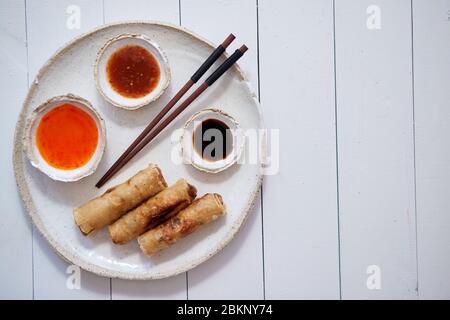 Gebratene chinesische Thai oder vietnamesische traditionelle Frühlingsrollen oder nems auf Keramikplatte serviert Stockfoto