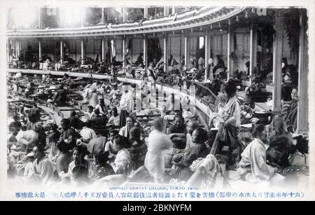 [ 1910 Japan - große Kanto-Flut, Tokyo ] - Menschen, die durch die Überschwemmungen vom August 1910 (Meiji 43), die heute als große Kanto-Flut bekannt sind (関東大水害, Kanto Dai Suigai), vertrieben wurden, suchen Zuflucht in der Kokugikan Sumo Hall in Tokio. Die Halle war im Vorjahr gerade eröffnet worden. Das Hochwasser, verursacht durch einen Sturm, versunkenen mehr als 201 Quadratkilometer und über 170,000 Wohnungen und Gebäude. Es gab 1,349 Tote oder Vermisste. Es war Tokyos drittschlimmste Flutkatastrophe des 20. Jahrhunderts. Vintage-Postkarte des 20. Jahrhunderts. Stockfoto