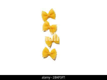 Rohe Stücke von italienischen Farfalle Pasta Stücke auf einem weißen Bachgrund isoliert. Italienische Küche. Draufsicht. Rohe Bio-Farfalle Pasta Stockfoto