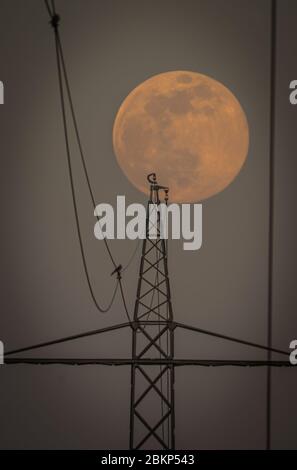 Einstellung Super Moon - Stromleitungen und Türme in ftont des Supermonds Stockfoto