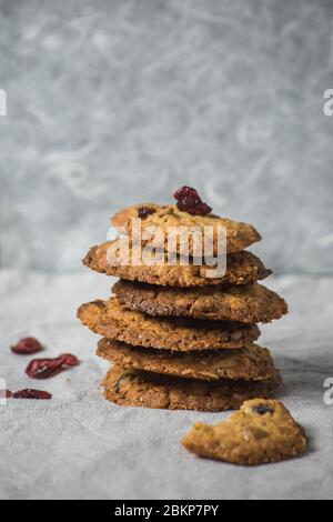 Gesunde Haferkekse mit Cranberry, handgemacht aus Vollkornmohn auf grauem Hintergrund. Stockfoto