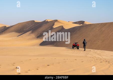 Mann in Schwarz auf roter Quad-Tour in der Wüste bei Swakopmund, Namibia Stockfoto