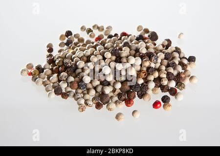 Weiße und schwarze Pfefferkörner auf weißem Hintergrund Stockfoto