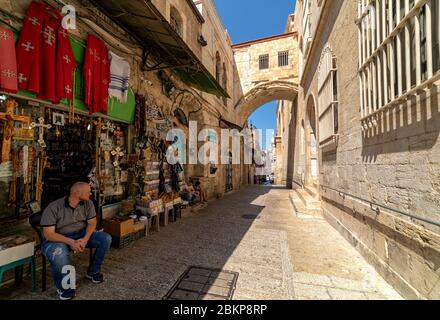 Verkäufer sitzt vor dem Souvenirladen in der Via Dolorosa Straße in der Altstadt von Jerusalem, Israel. Stockfoto