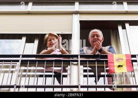 Ältere Paare klatschen im Fenster zur Unterstützung von Menschen gegen das Coronavirus Stockfoto