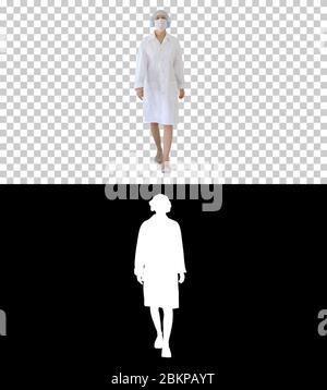 Walking weibliche Arzt trägt chirurgische Maske, Alpha-Kanal Stockfoto