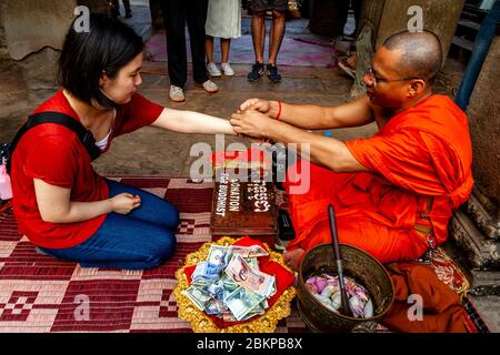 Ein buddhistischer Mönch, der einen Segen gibt, Angkor Wat, Siem Reap, Provinz Siem Reap, Kambodscha. Stockfoto