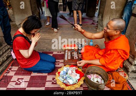 Ein buddhistischer Mönch, der einen Segen gibt, Angkor Wat, Siem Reap, Provinz Siem Reap, Kambodscha. Stockfoto