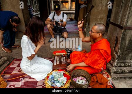 Ein buddhistischer Mönch, der einen Segen gibt, Angkor Wat, Siem Reap, Provinz Siem Reap, Kambodscha. Stockfoto