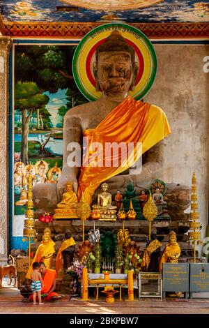 Ein buddhistischer Mönch und Kind sitzen an EINER großen Buddha-Statue im Angkor Wat Temple Complex, Siem Reap, Provinz Siem Reap, Kambodscha. Stockfoto