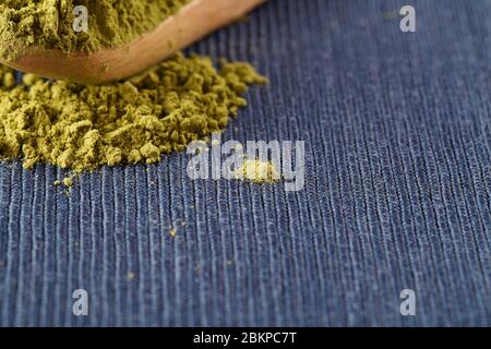 matcha grüner Tee Pulver in Holz Löffel auf blauem Hintergrund. Top-Ansicht Kopierraum gesunde Ernährung Konzept selektiven Fokus Stockfoto