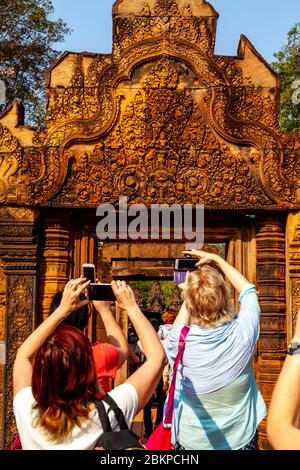 Besucher, die Fotos machen, im Banteay Srey Tempel, Angkor Wat Temple Complex, Siem Reap, Kambodscha. Stockfoto