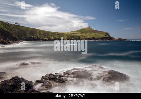 Cape Cornwall vom Ende des Kenidjack Valley aus gesehen, mit Blick auf Porth Ledden, mit Felsen im Vordergrund, die durch Bewegungsunschärfe des weißen Wassers verstärkt werden Stockfoto