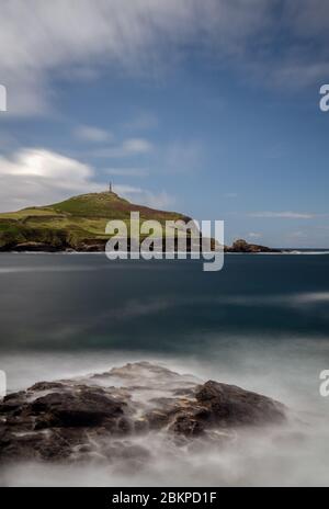 Cape Cornwall vom Ende des Kenidjack Valley aus gesehen, mit Blick auf Porth Ledden, mit Felsen im Vordergrund, die durch Bewegungsunschärfe des weißen Wassers verstärkt werden Stockfoto