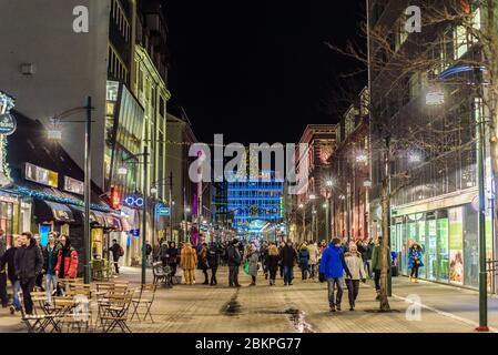 Menschen, die in der Austurstraeti Straße an einem Winterabend im Zentrum von Reykjavik, Island, spazieren gehen. Stockfoto